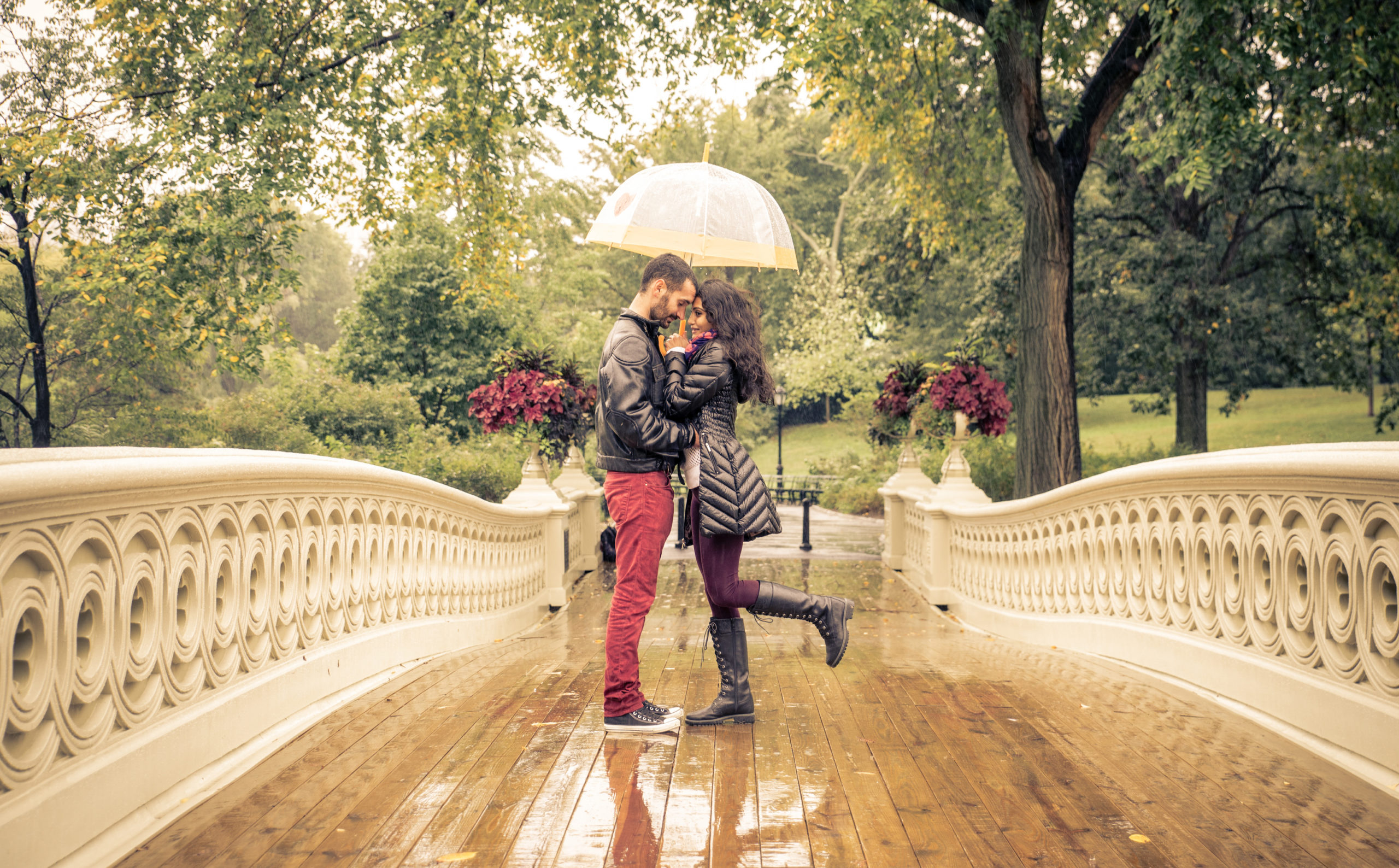 A romantic proposal on a bridge in the rain.